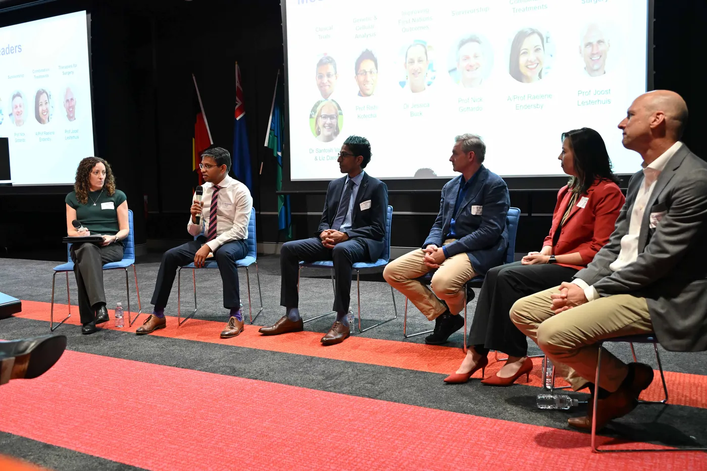 6 people sitting on a stage in a panel setting.