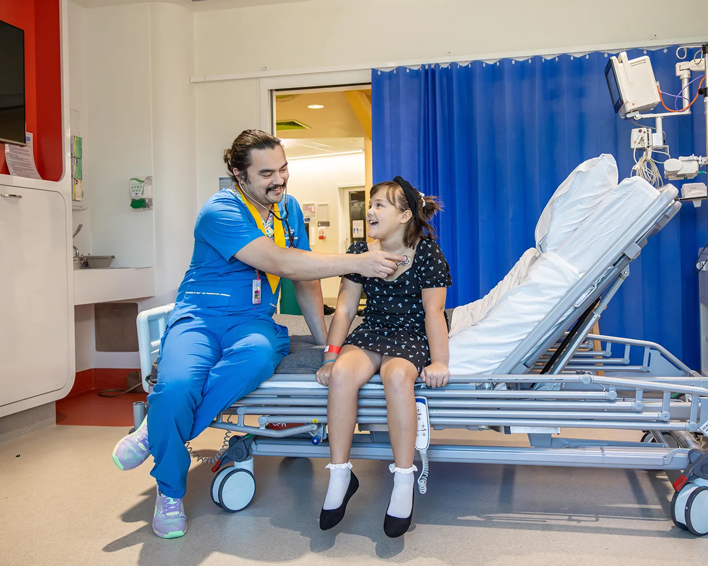 nurse with young girl on hospital bed