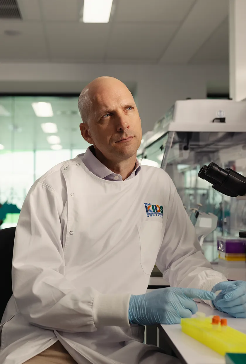 A male scientist in a lab with a thinking face on.