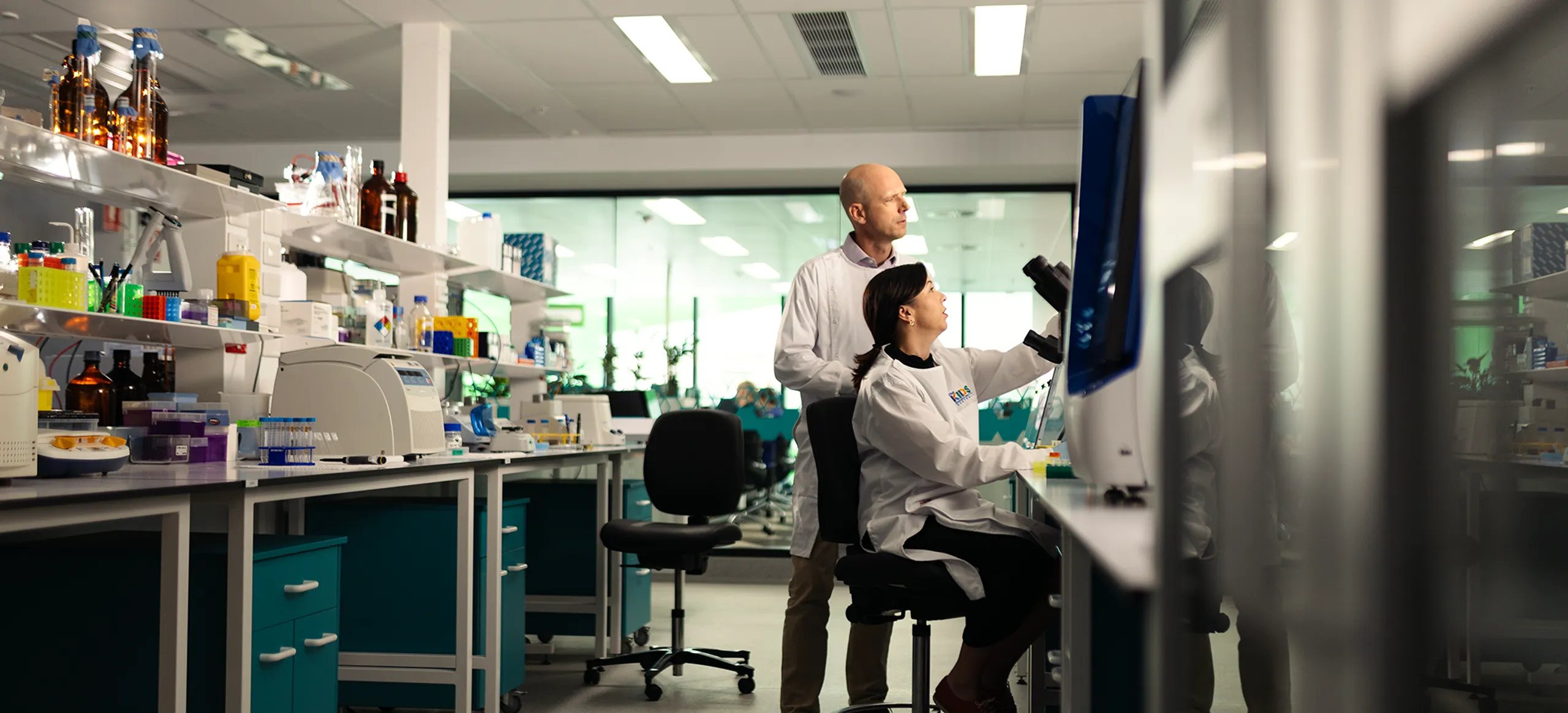 Two researchers in a lab looking at equipment.