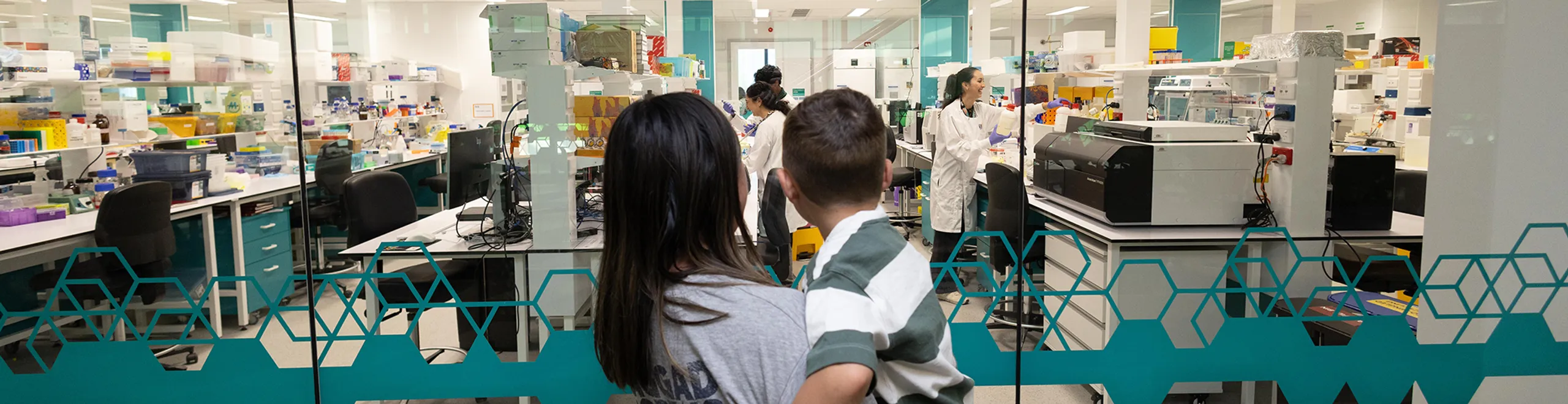 Mum and son looking into lab.