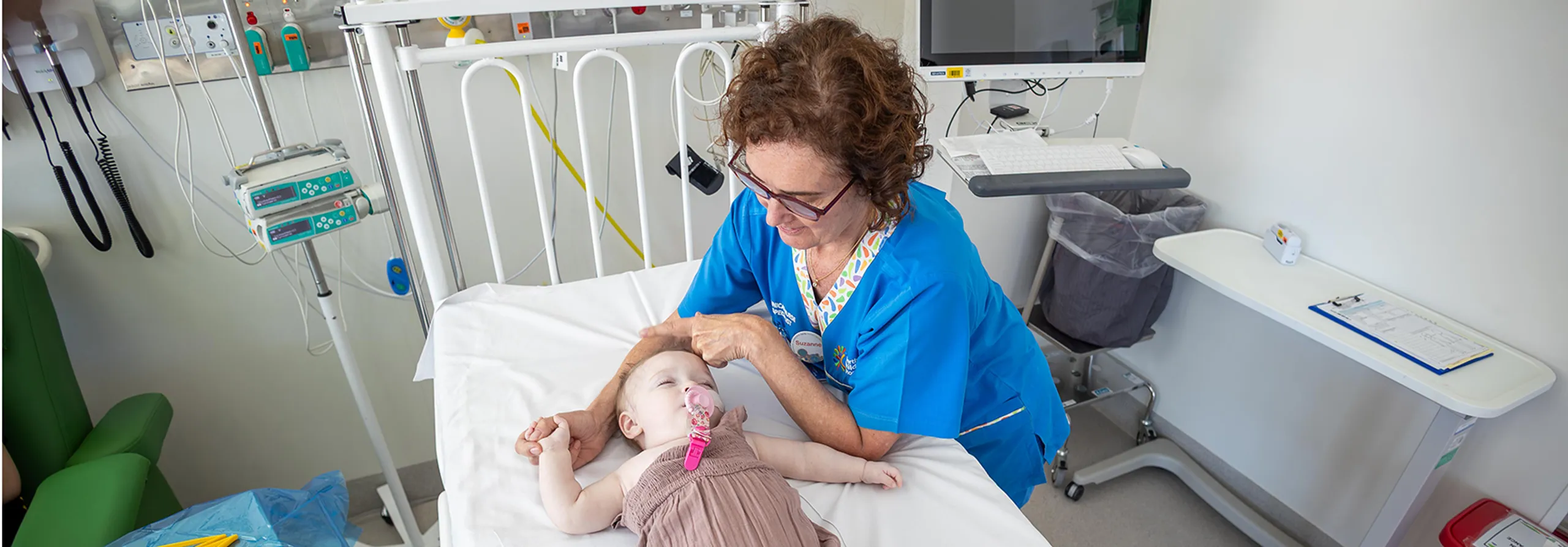 A nurse looking at a baby.