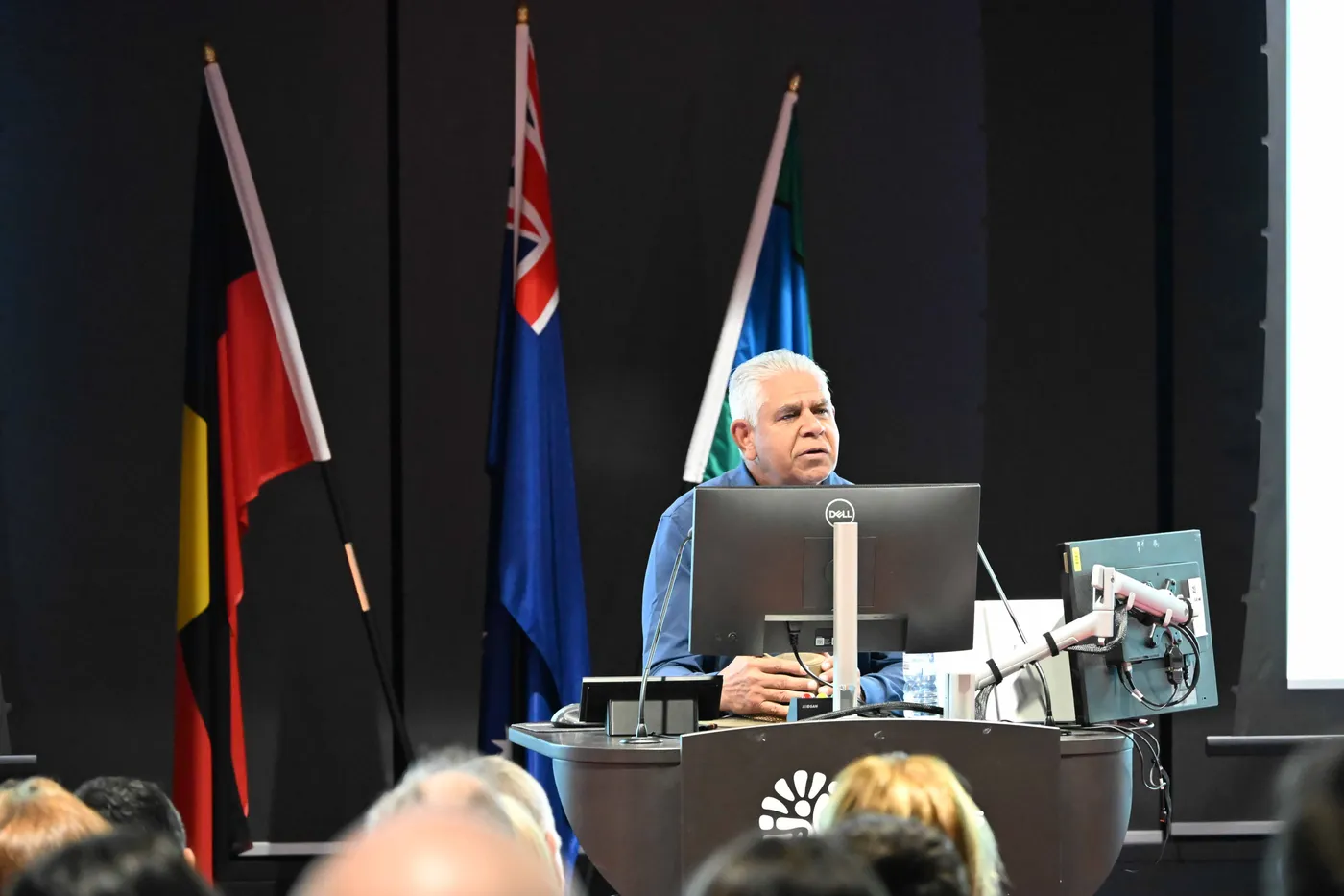 A man speaking at a lectern 