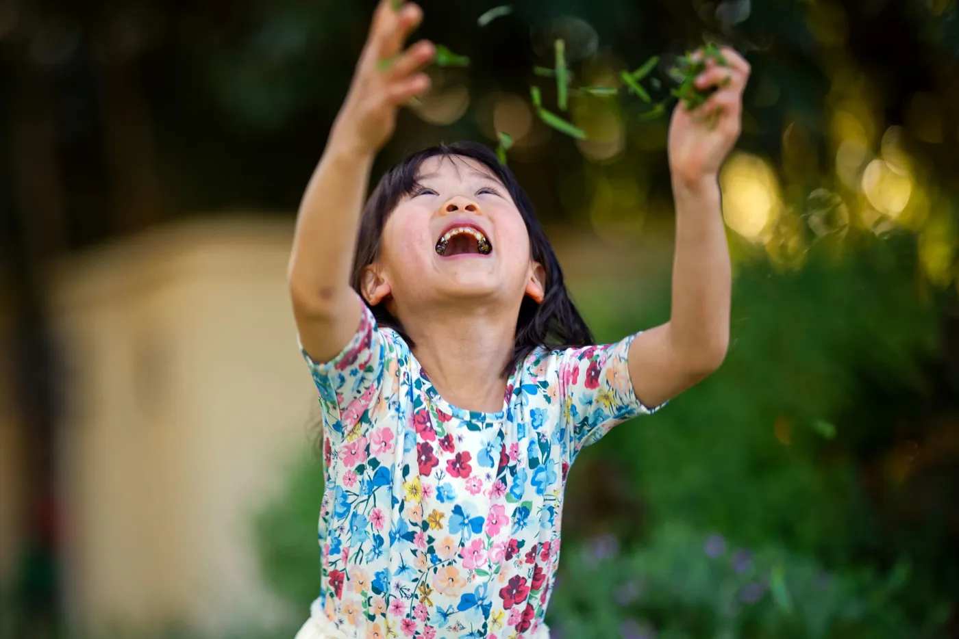 A young girl throwing grass in the air