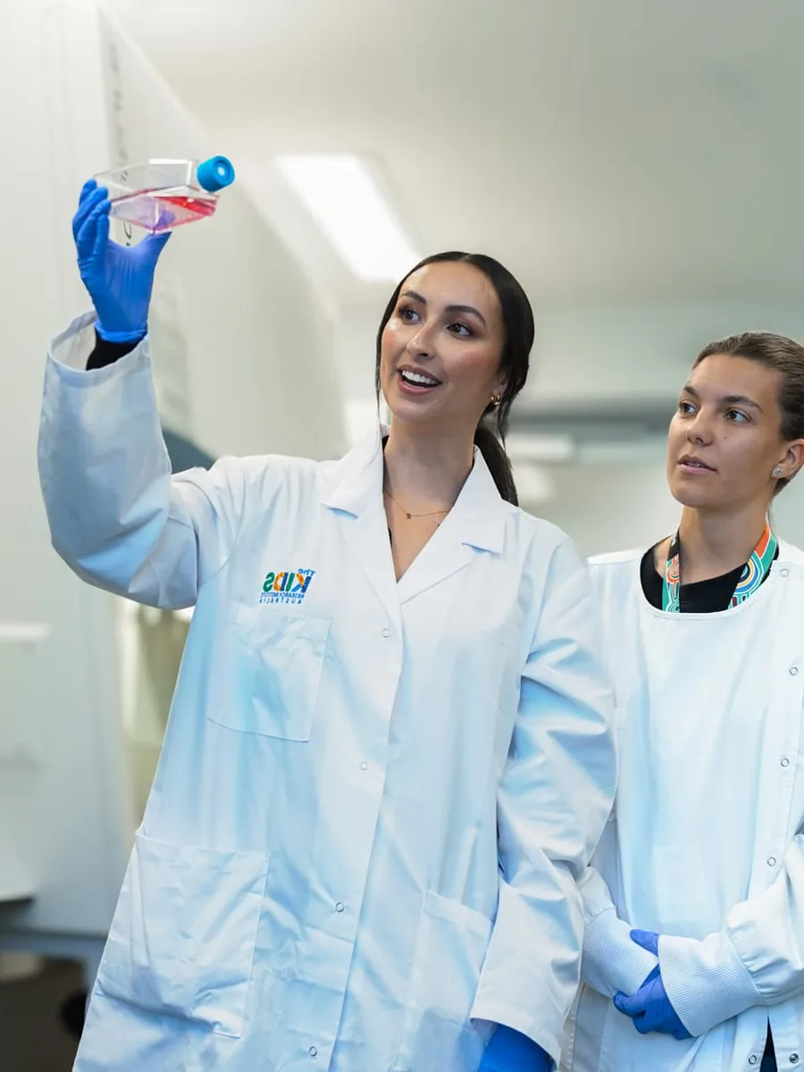 two researchers in lab holding up sample