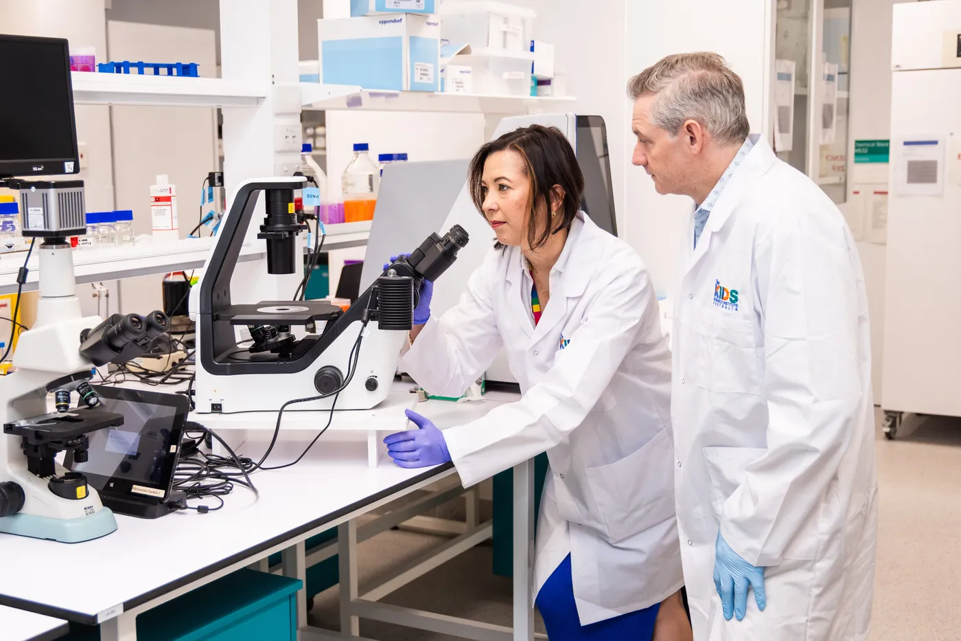 Two researchers looking at a microscope.